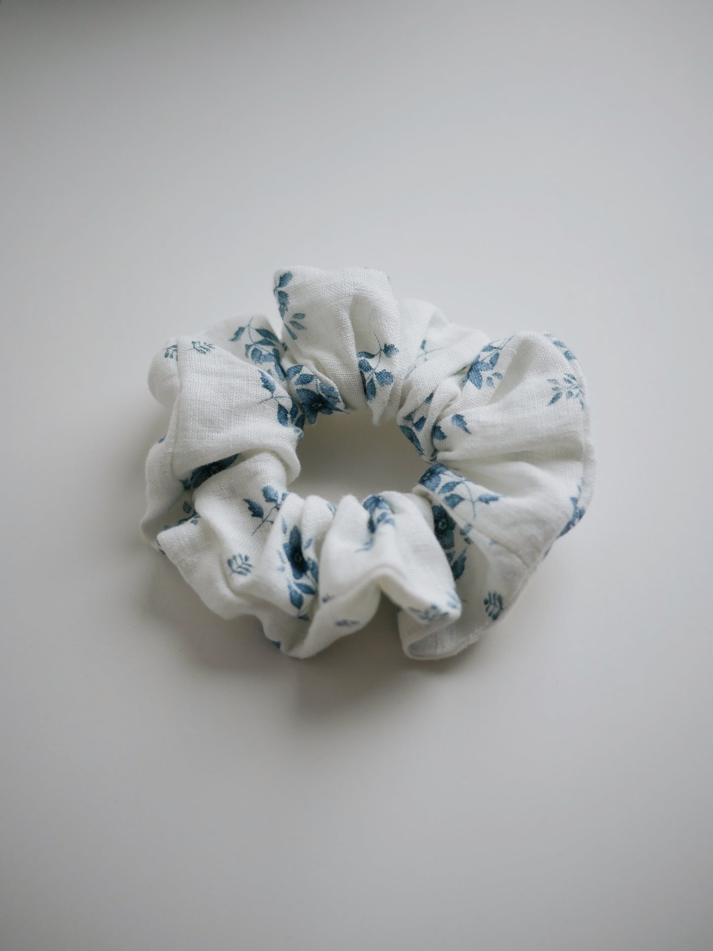 Scrunchie i linnetyg med blå blommor