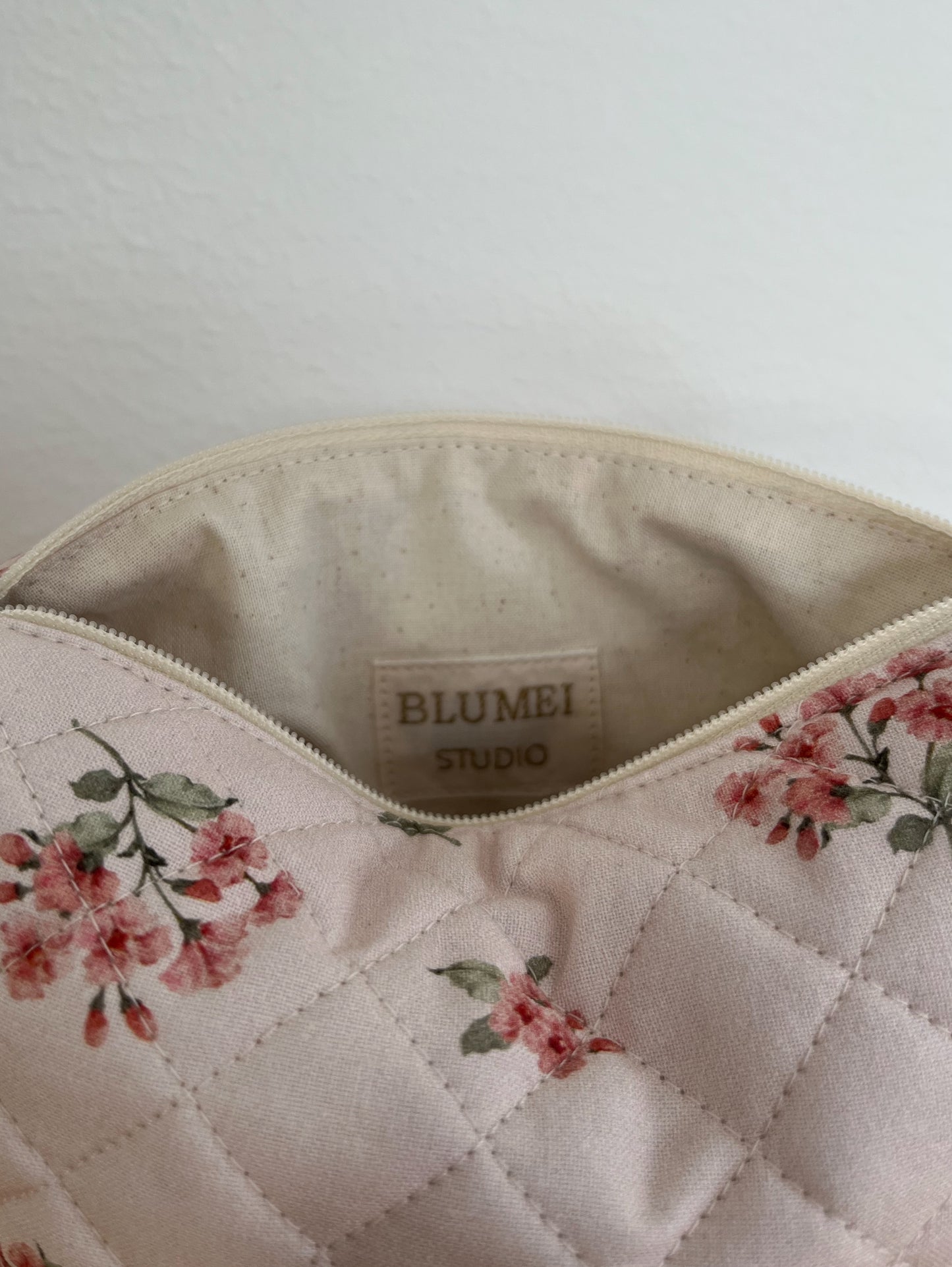 Quiltad blommig necessär rosa
