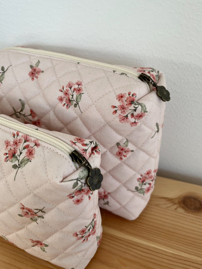 Quiltad blommig necessär rosa