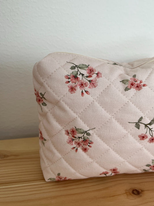 Quiltad blommig necessär rosa