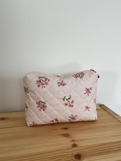 Quiltad blommig necessär rosa